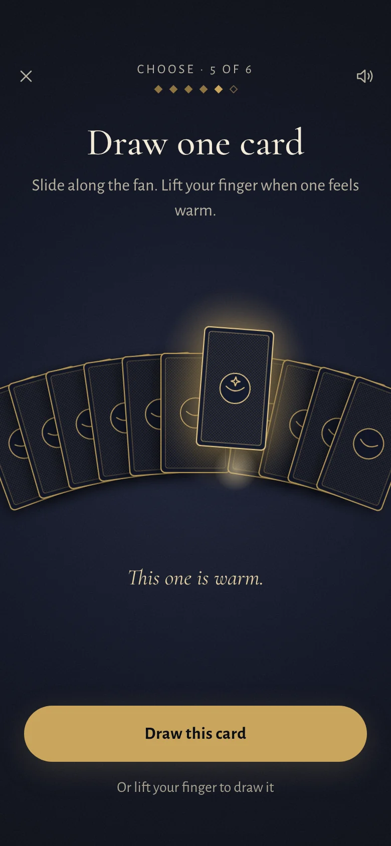 Choosing a card: a fan of face-down cards where one glows warm under the finger.